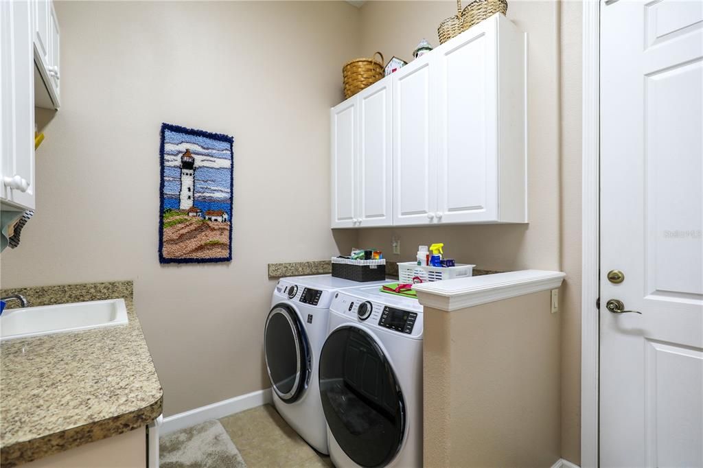 Laundry room with built in cabinets, mud sink and storage closet