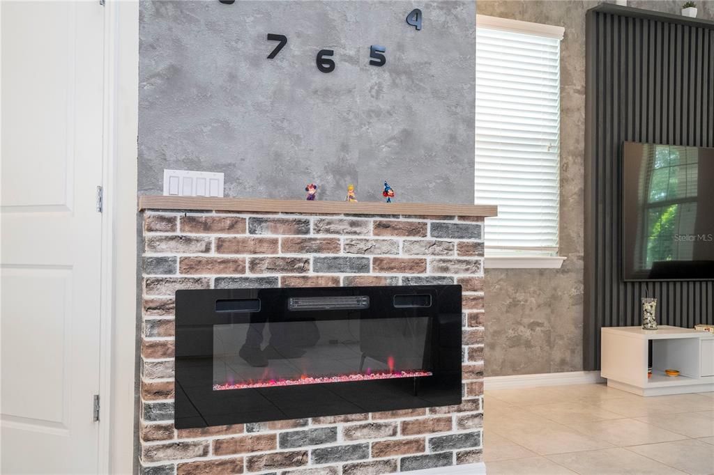 Accent wall with electric modern fireplace and wall clock.