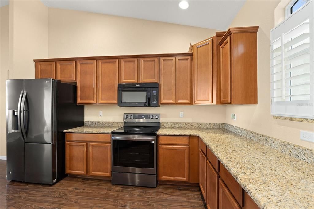 Kitchen With Matching Black Appliances and Granite Countertops