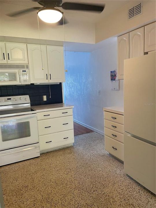 Terrazzo flooring in kitchen and the refrigerator is new.