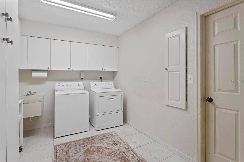 Large laundry Room with wet tub, ample storage and built in ironing board.