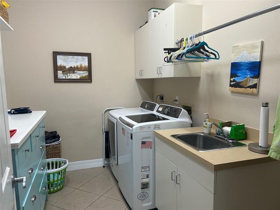 Laundry room has sink and built in storage