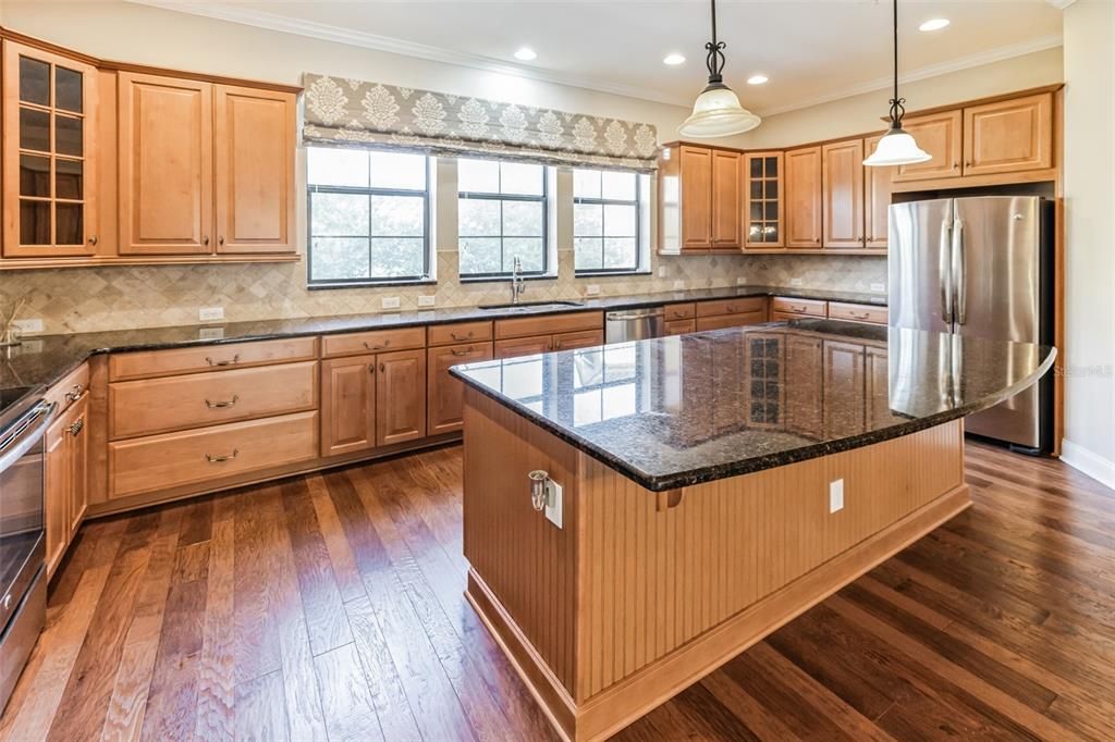 Expansive kitchen with stone counters.