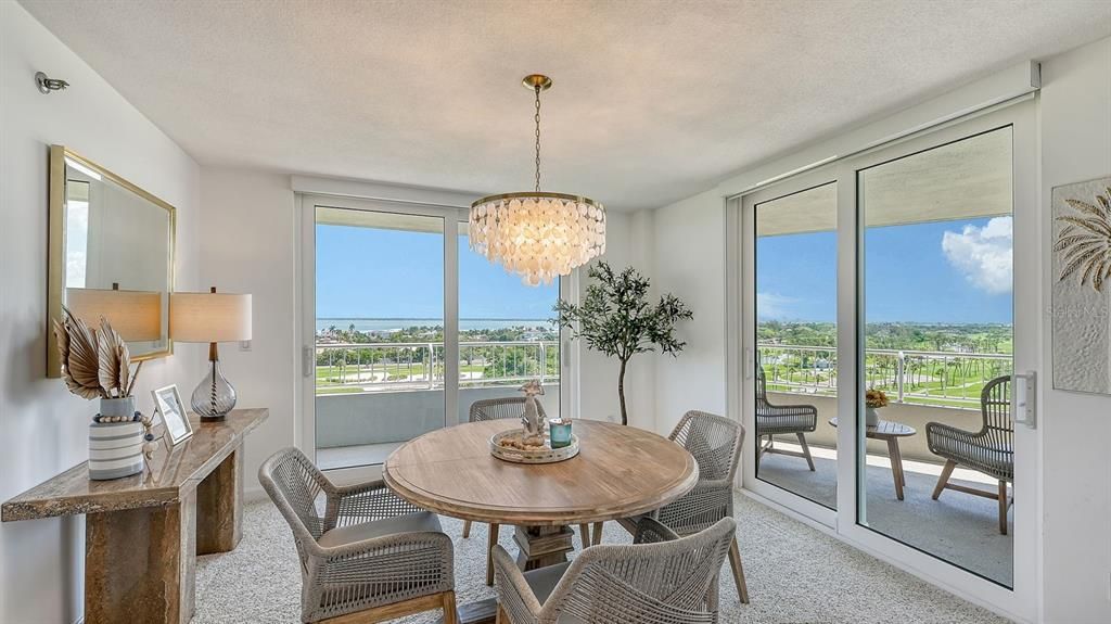 Dining room - two sets of sliding doors open to the wraparound balcony. Sarasota Bay and golf course views.