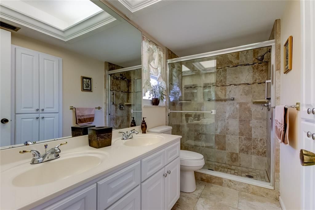 primary en suite bath with walk in shower and dual vanity