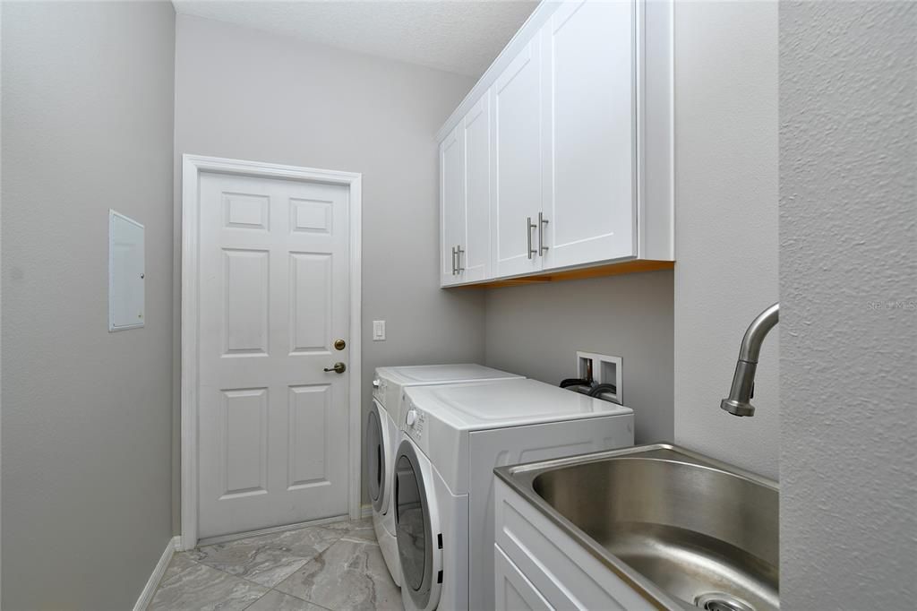 Laundry room has deep sink and cabinetry