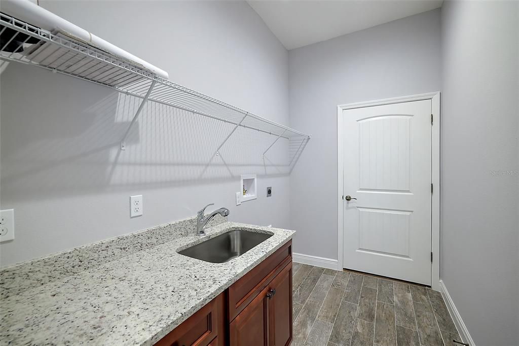 oversized laundry room with sink and cabinets