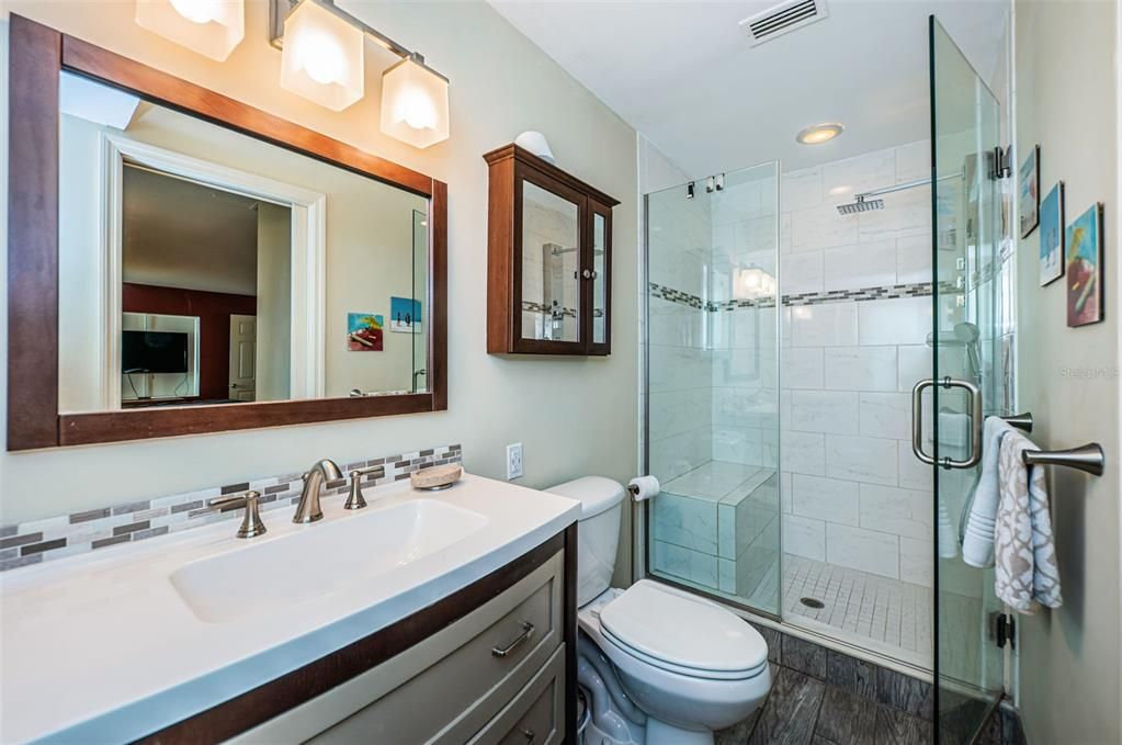 Come to the master bathroom, your private spa! There's a nice sink, drawers, and a see-through divider to the shower. It's a comfy spot to get clean and relax.