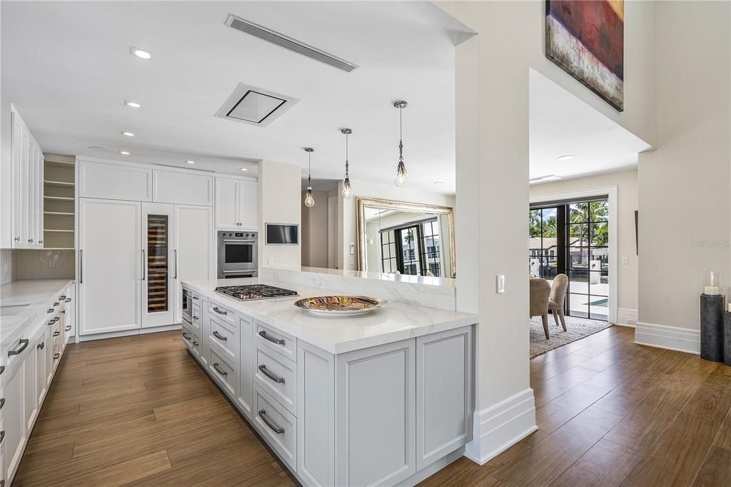 The gourmet kitchen, featuring custom Shaker-style cabinetry, Calacatta marble counters, and professional-grade appliances, is a culinary enthusiast's dream.