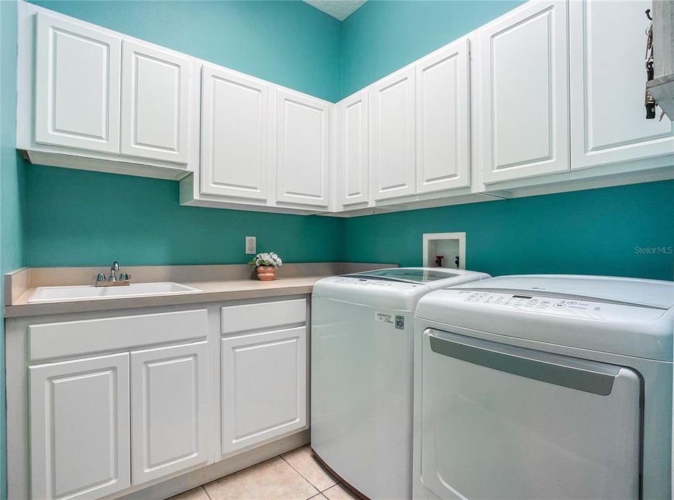 Laundry room with a deep sink, storage galore with washer and dryer
