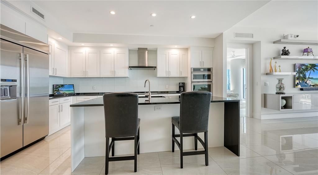 The dramatic black-and-white kitchen has high-end appliances and double oven