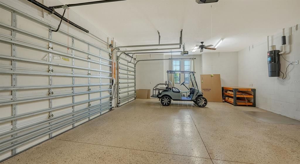 Three car garage with epoxy floor coating, utility sink, EV charging station, central vacuum canister, and water purification equipment.