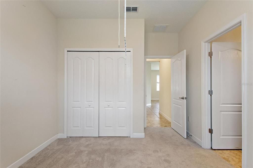 Bedroom 3 with ceiling fan and large standard closet.