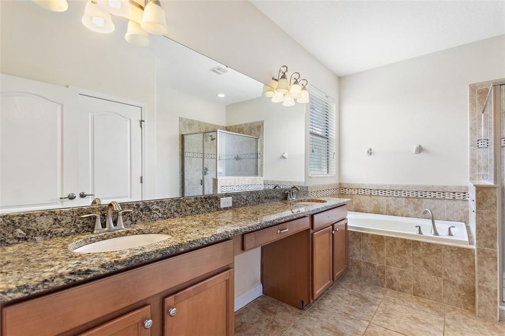 Master bathroom with dual sinks, vanity area, and water closet.