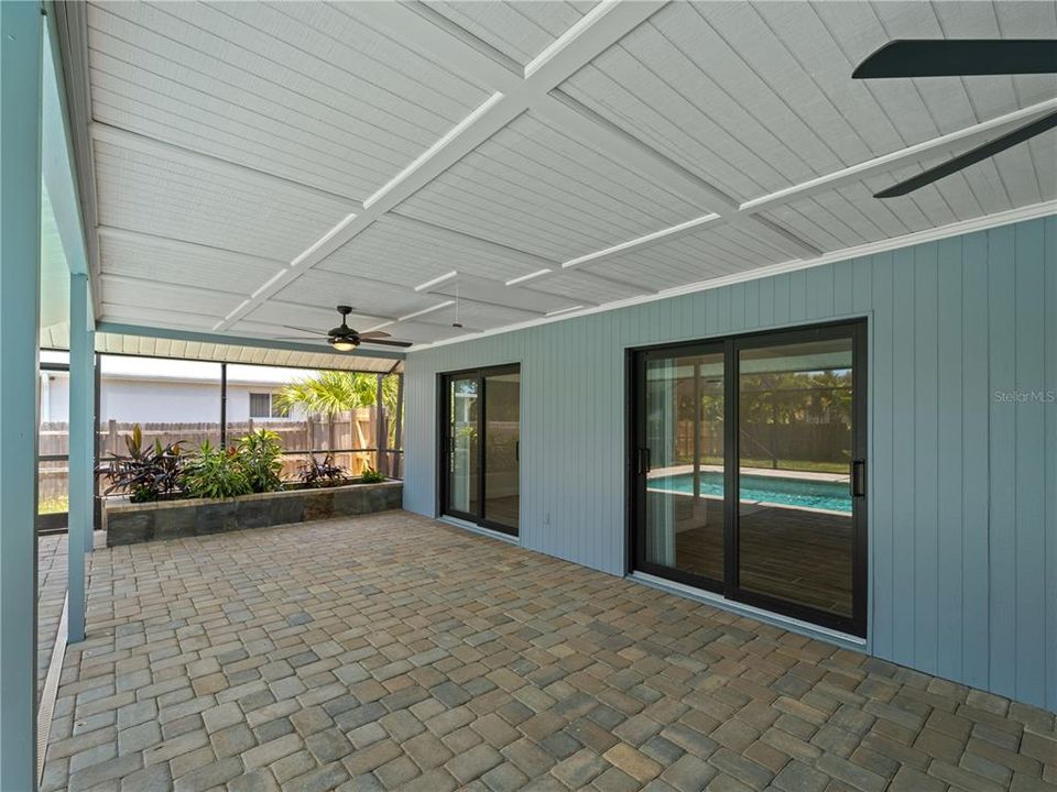 Oversized lanai with new ceiling fans and pavers.