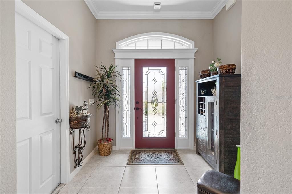 Foyer with Tiled floors and crown molding. Garage through the door to left in picture.