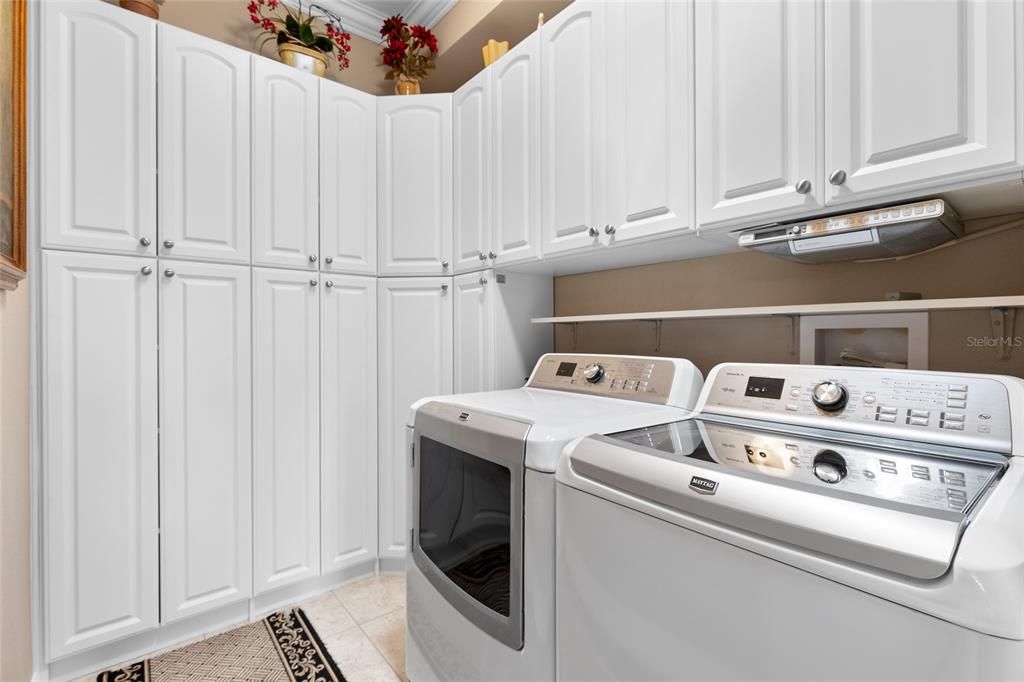 Inside Laundry with full length cabinets, solar tube.