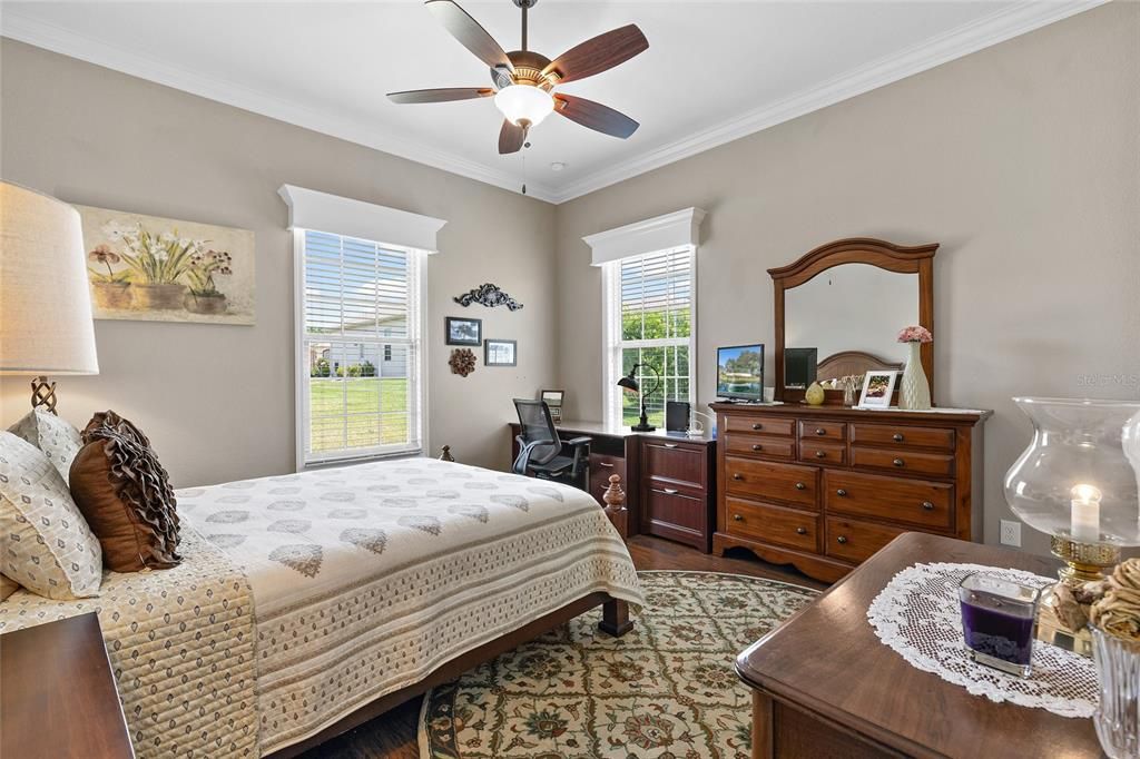 Third bedroom with crown molding, laminate floors, cornices, storage above closet.