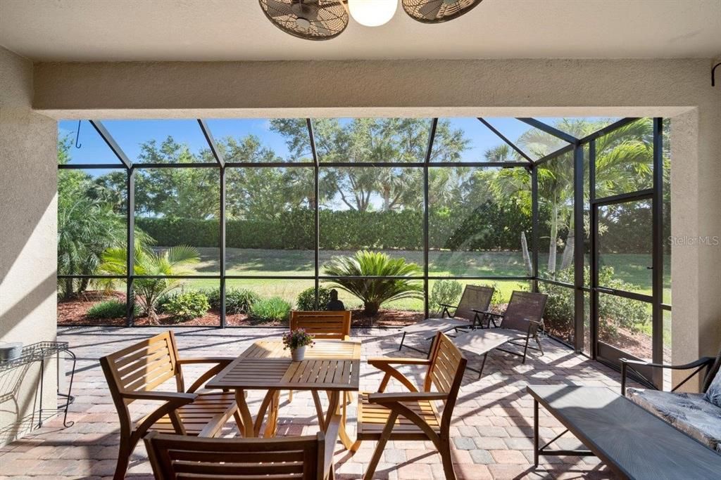Large extended screened-in lanai with a semi-private back yard.