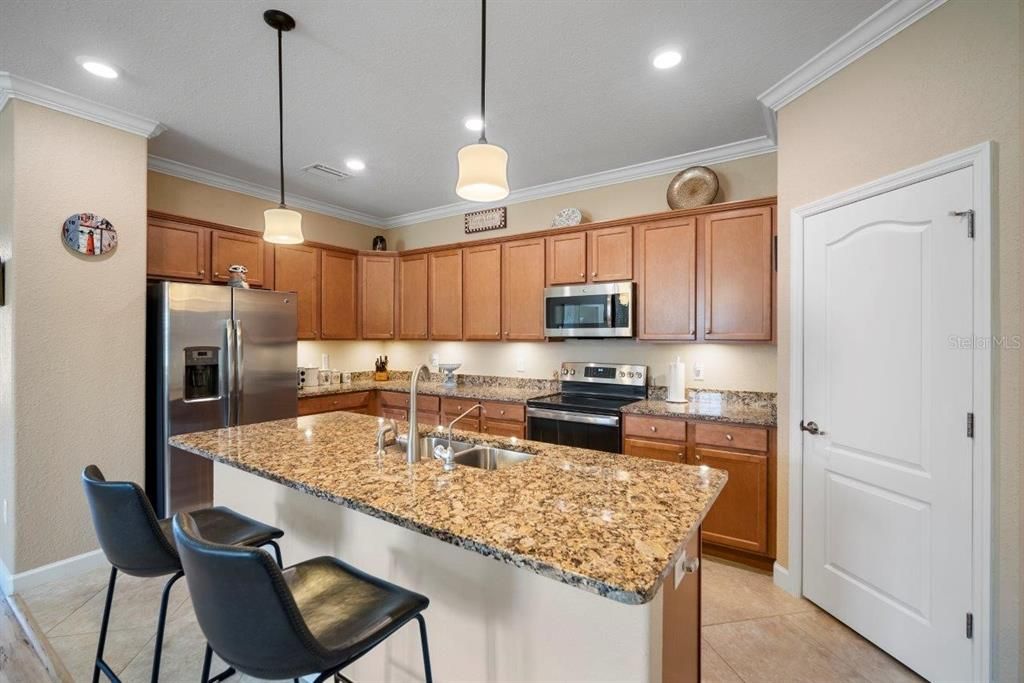 Stunning Kitchen featuring a large island, granite countertops, stainless steel appliances, and a pantry.