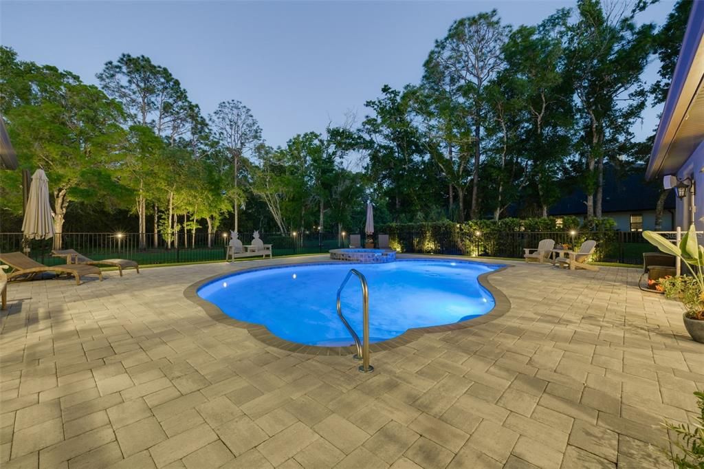 Pool with paver patio and lush privacy landscaping