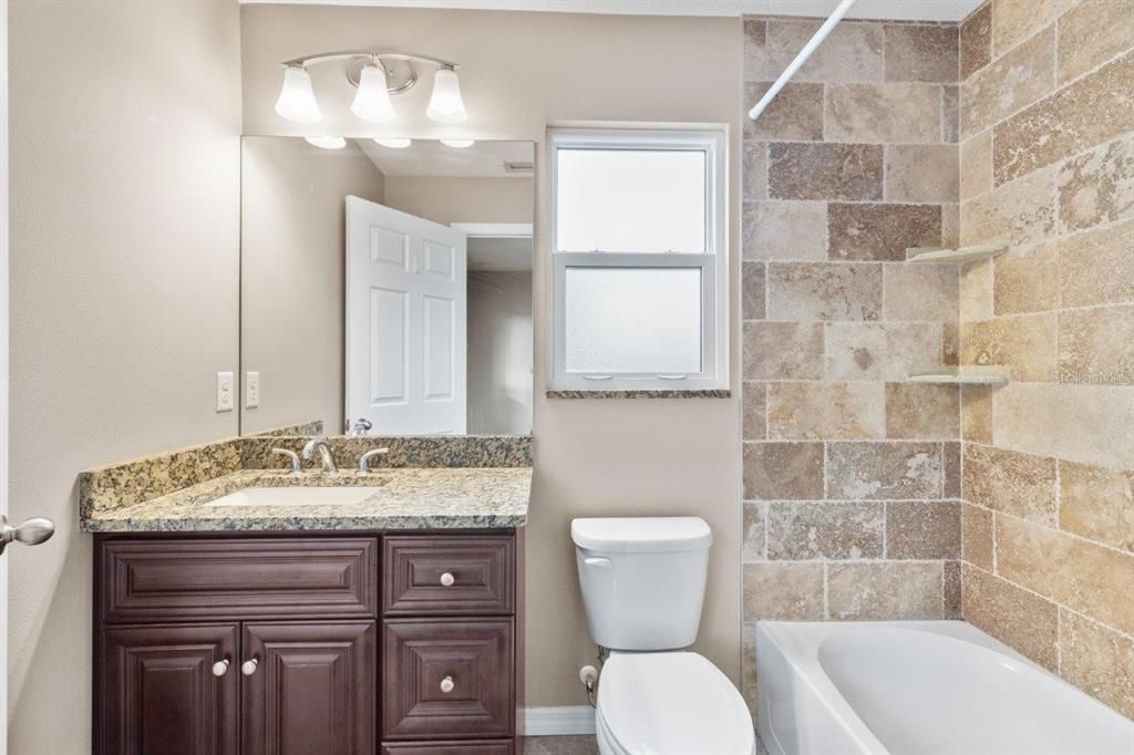Owners ensuite bathroom featuring granite countertops, and an alcove tub. *Photo of 3857 Almond Ave, Sarasota, FL 34234*