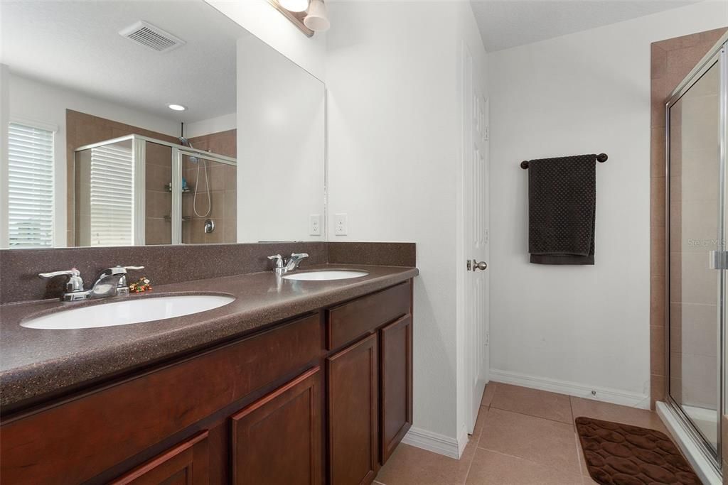 Primary bathroom featuring a dual vanity and walk-in shower