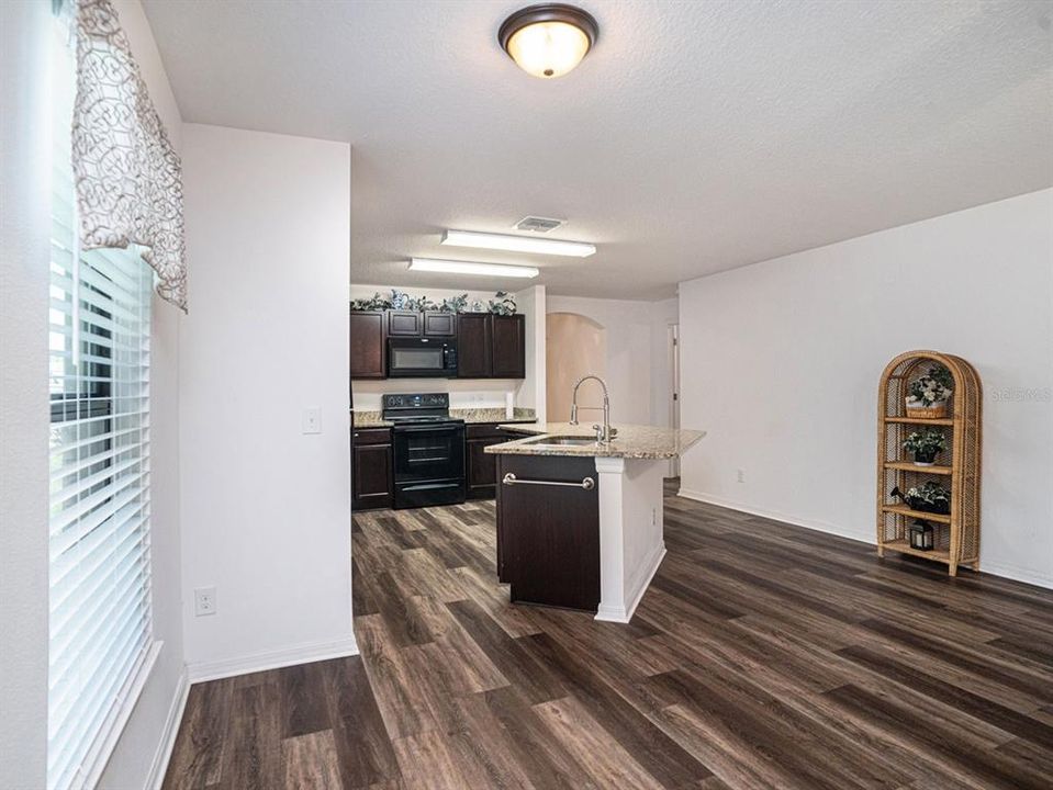 Great Room View of Kitchem  With Granite Counters, Whirlpool Appliances, Pantry, & Luxury Vinyl Floors