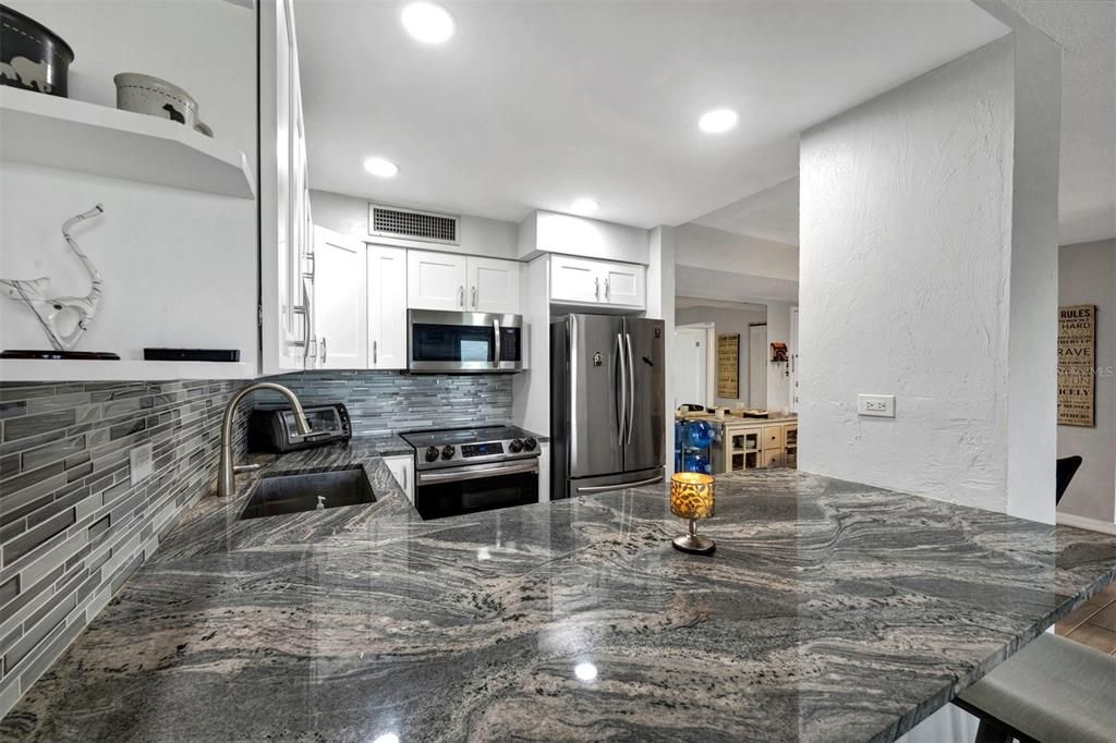 View from breakfast bar & Living room into the kitchen