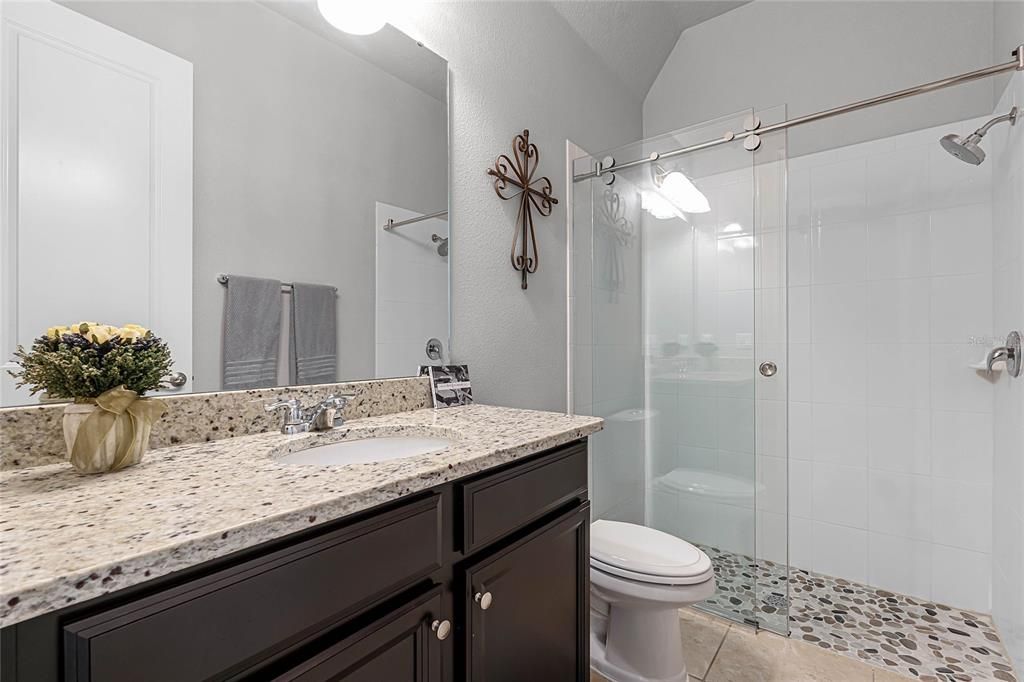 full bath with granite vanity area and shower