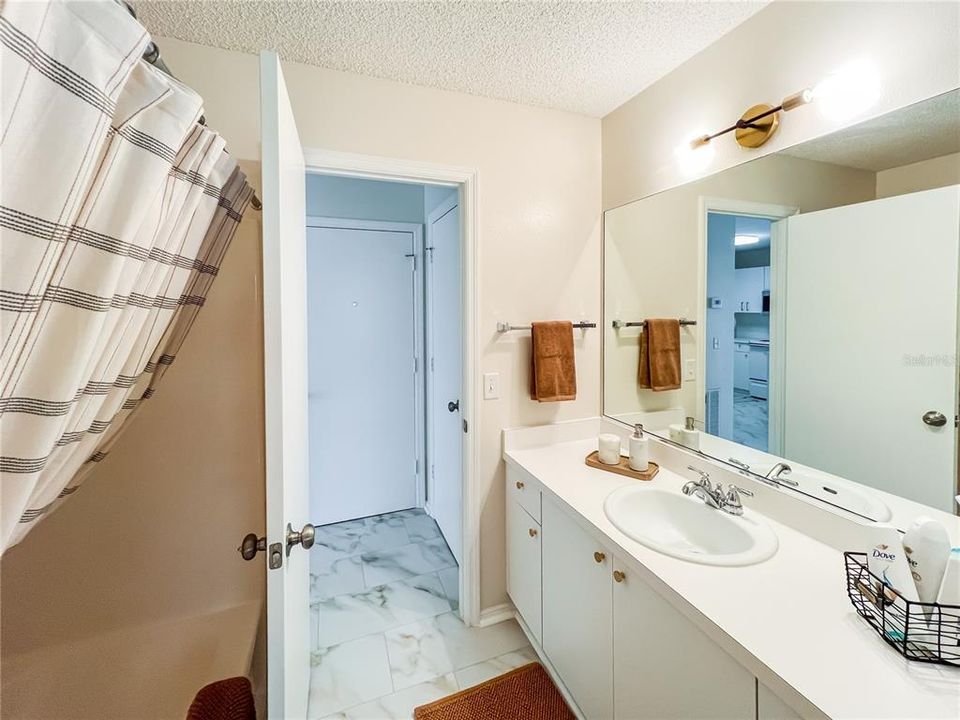 Main Bath featuring a Tub/Shower, large vanity and a fully stocked linen closet