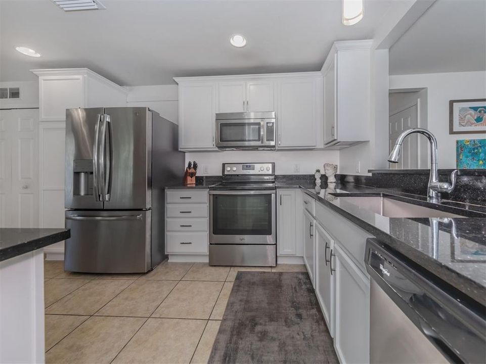 The kitchen is well adorned with solid wood cabintery, granite countertops and stainless steel appliances