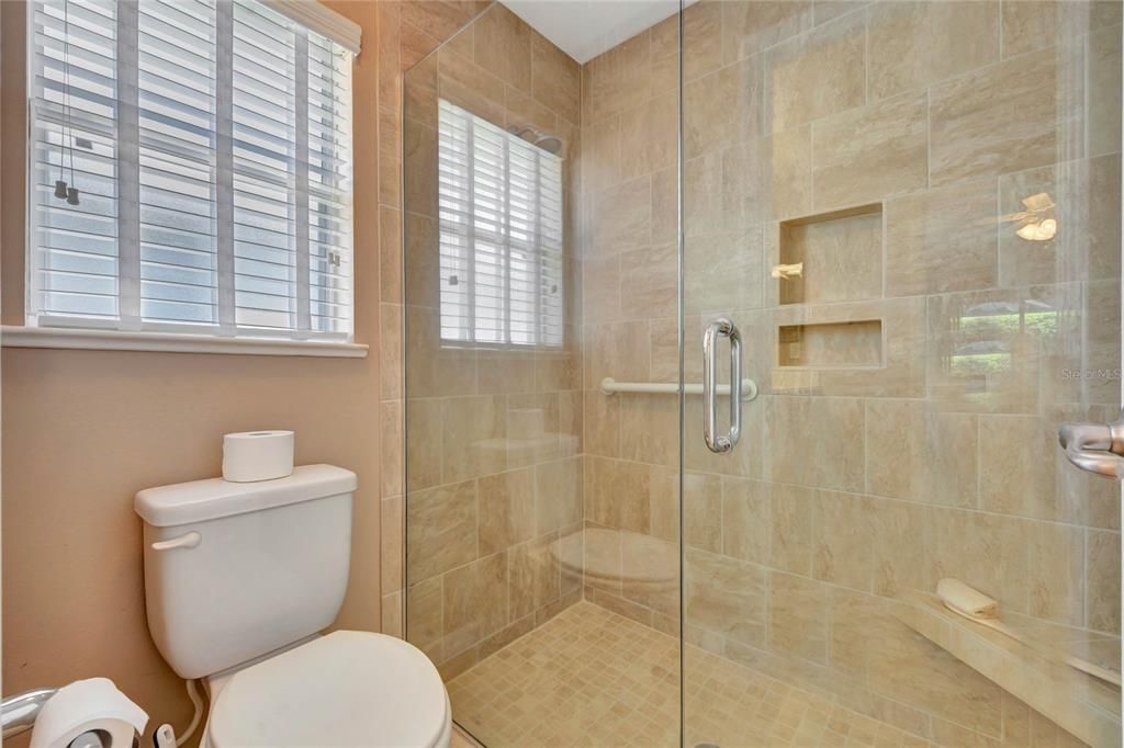 Water Closet and Tiled Shower with Safety Grab Bar