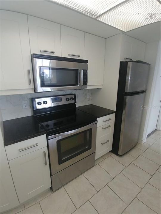 Beautifully renovated kitchen with granite counters and bright cheery cabinets.