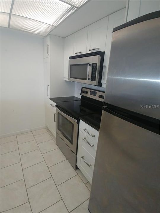 From entrance to kitchen with stainless steel appliances.