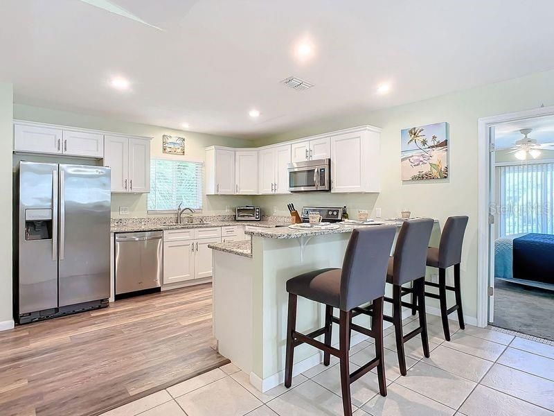 Kitchen view 1: Breakfast bar, vinyl flooring, stainless steel appliances, Granite counters, recessed lighting