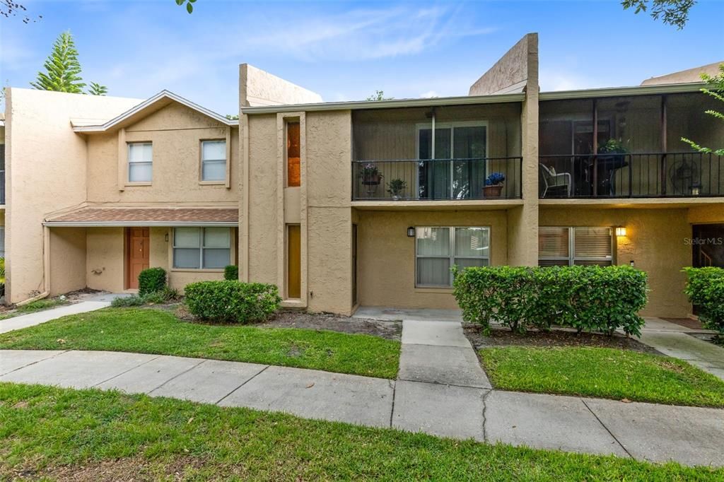 Front elevation with entrance and exterior view of second floor screened balcony.