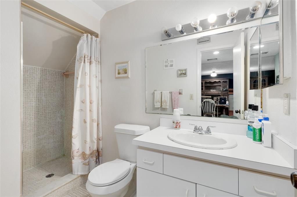 A full bath with a walk-in shower is conveniently located nearby, making it great for guest use.