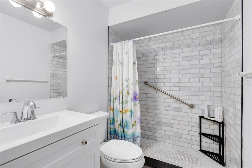 The secondary master bedroom features a completely updated en suite bath with a modern sink and a fully tiled walk-in shower.