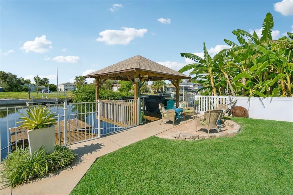 Waterfront living showing Tiki hut and fire pit