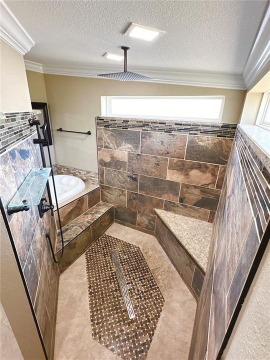 Large walk-in shower with waterfall showerhead and bench
