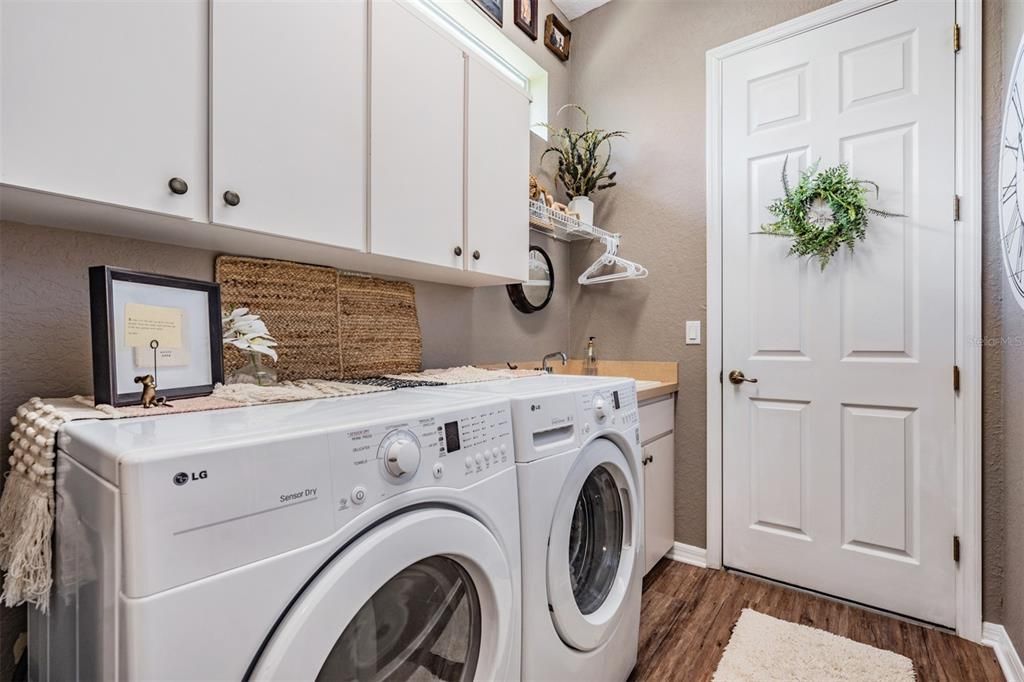 Interior laundry room with cabinets above