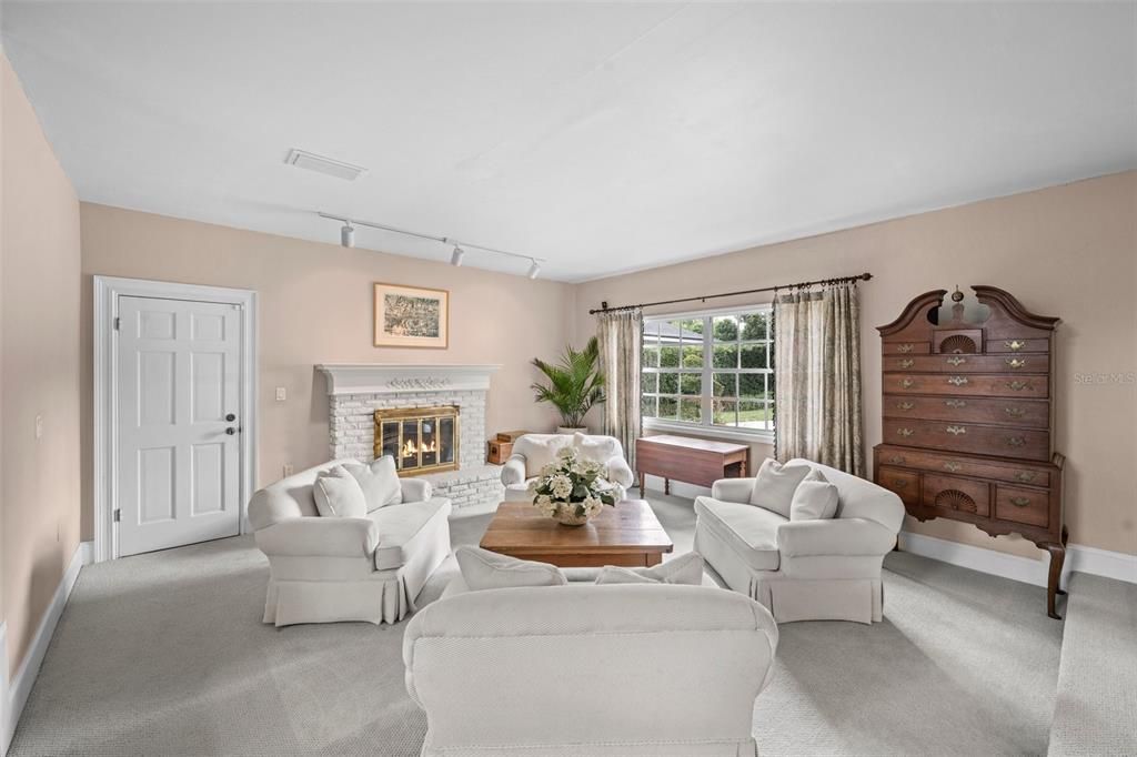 Cozy sunken family room with high ceilings and a wood-burning fireplace