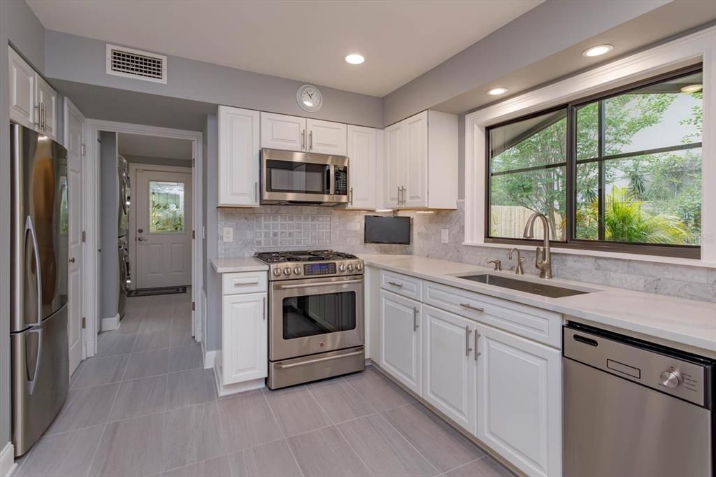 Stainless refrigerator, gas stove, microwave, dishwasher, disposal, designer fixture, under cabinet lighting, water filtration system, and even a TV to enjoy while you are preparing your gourmet meals!
