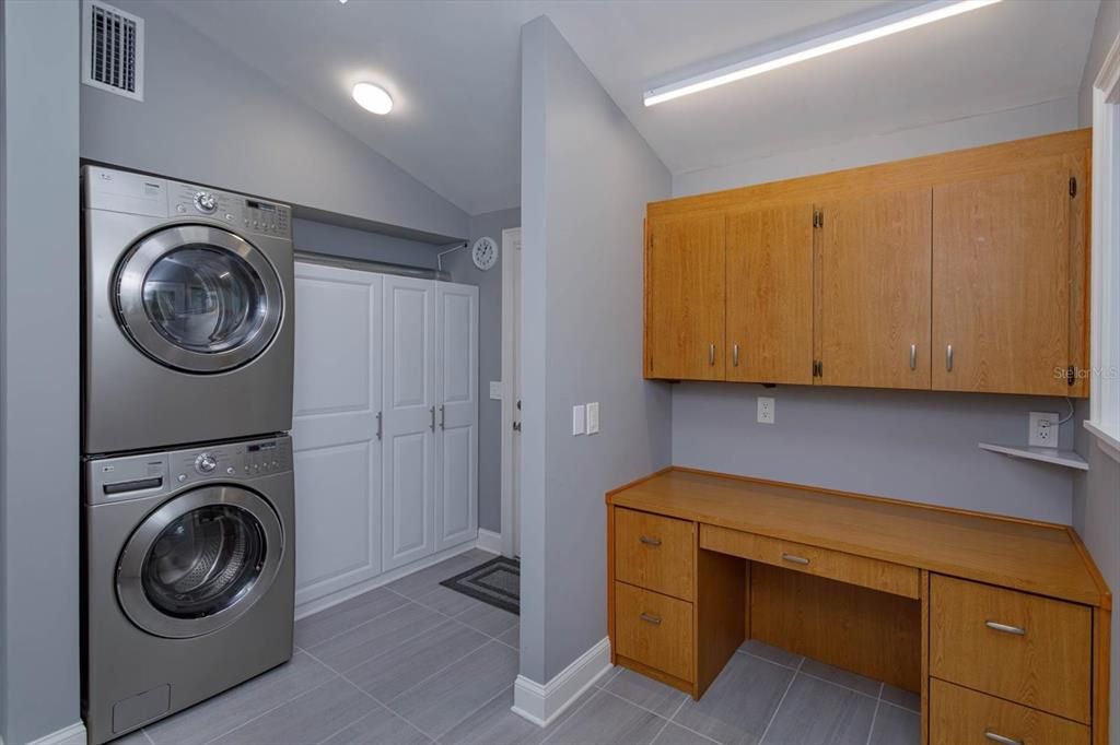 Large Laundry Room and Office Combo!  This room features: Lots of storage, full size Washer and Dryer, a built in Ironing Board, a Gas hot water heater and a secure entrance to the carport and the screened in patio!