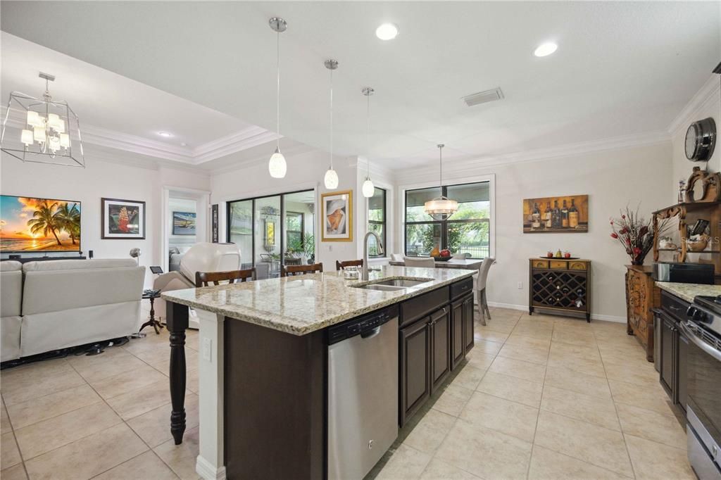 Large living room with triple crown molding and multiple tray ceiling giving spacious feeling perfect for gatherings. New chandelier gives this classy home a modern touch.