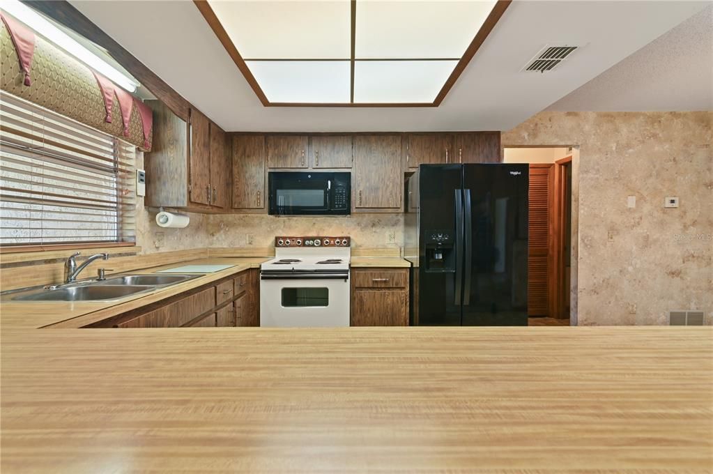 The kitchen provides ample room for preparing meals while looking out to the backyard.