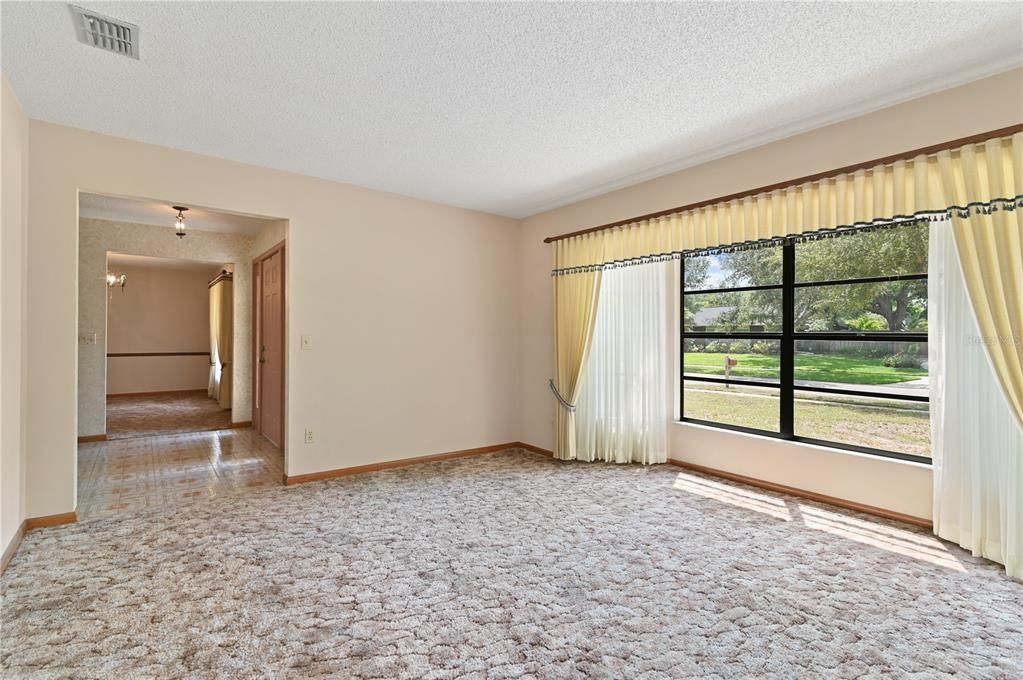 A view of the living room looking toward the front door and over to the dining room.