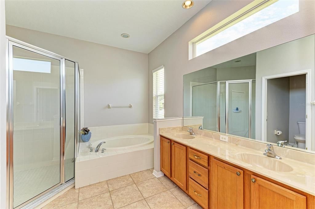 Primary bathroom with dual sinks, soaking tub and a large walk in shower.