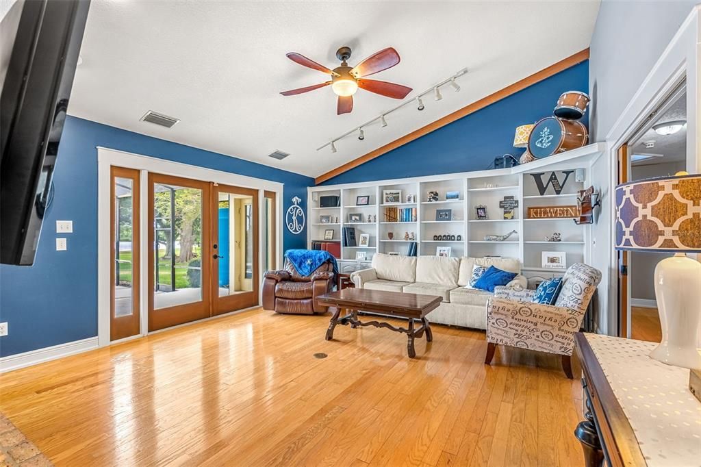 Vaulted ceilings, built-ins and french doors in this rear living room